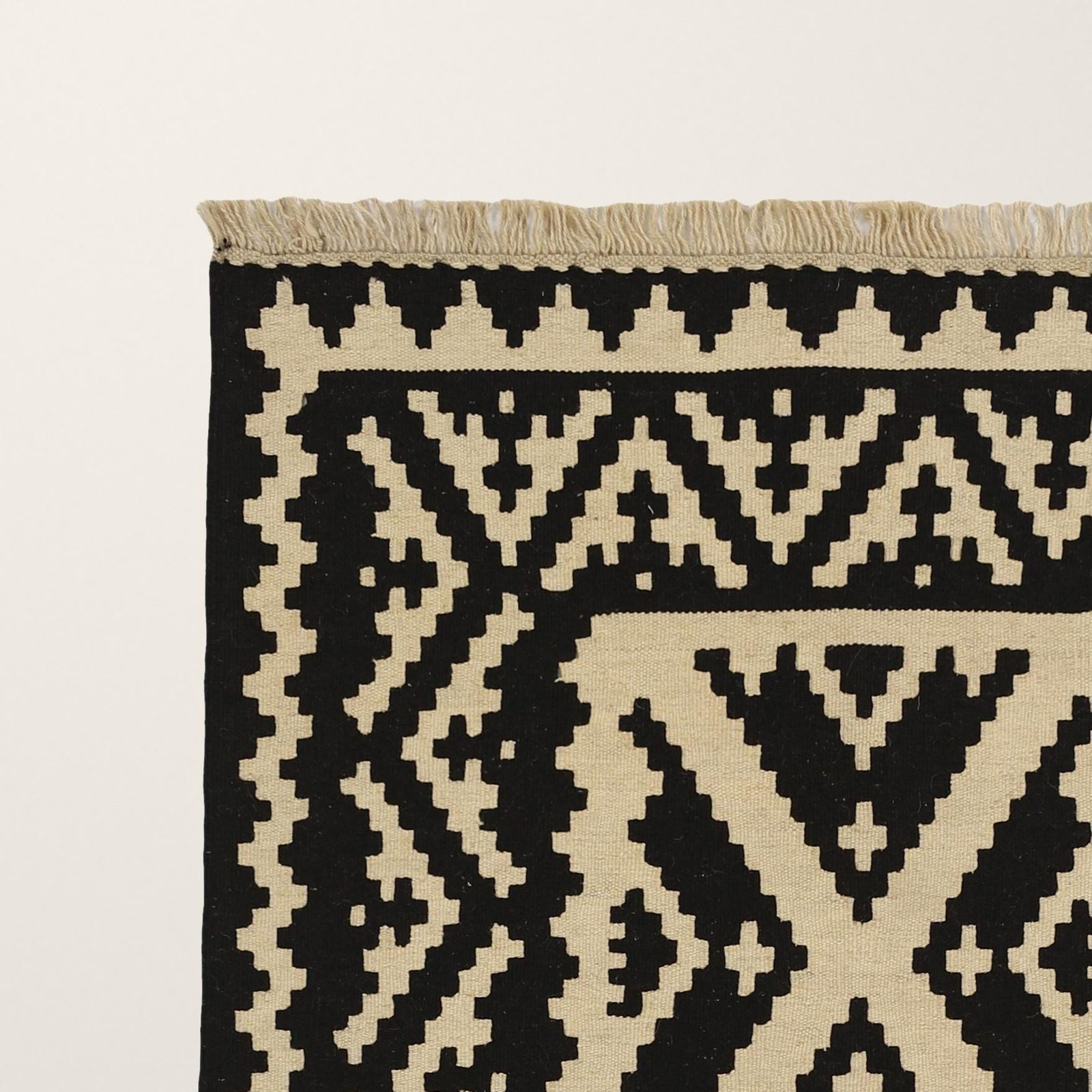Ecke mit Fransen, schwarze Motive auf Creme