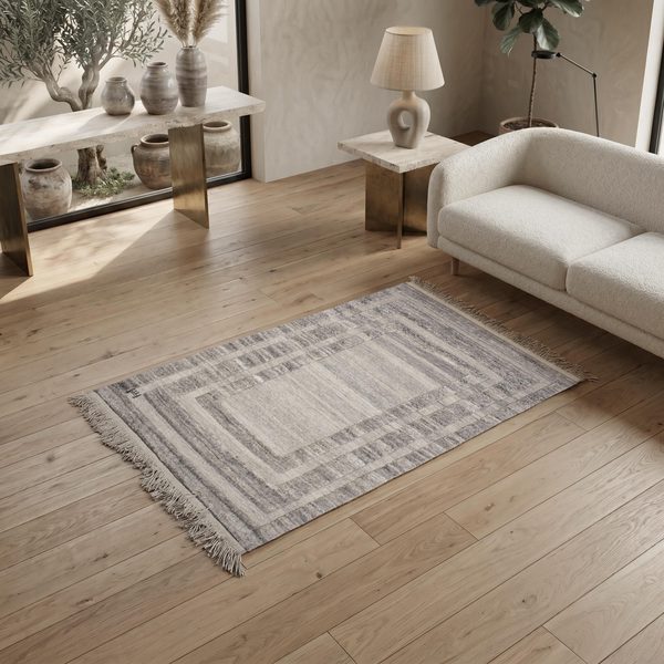 Grau-cremefarbener Gabbeh Kelim im Wohnzimmer vor einem hellen Sofa