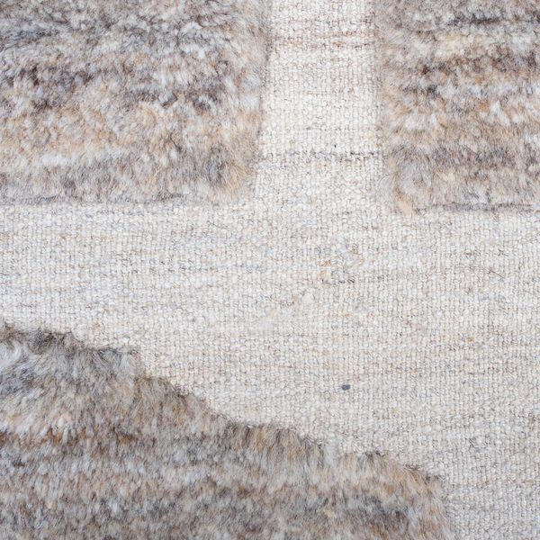 Detail: flache beige Fläche neben grauem Flor